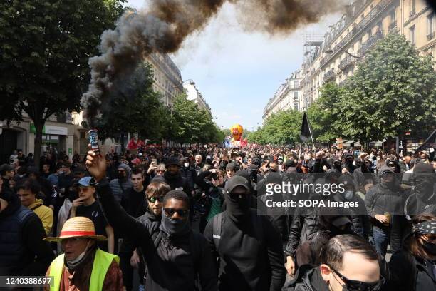 Masked protester holds a smoke flare during the traditional May Day labour union march in Paris. Thousands of demonstrators joined the May Day March...