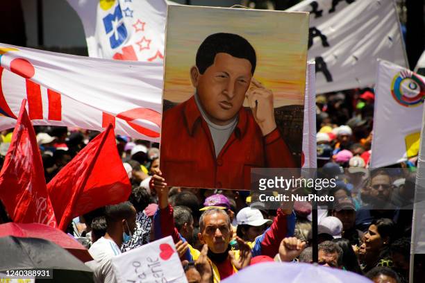 Man holds a picture of late President Hugo Chavez during a march to celebrate International Workers Day through downtown Caracas, Venezuela on May 1,...