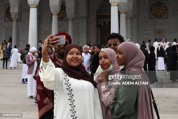 Foreign Muslims living in Turkey pose for pictures after the prayers at the Melike Hatun Mosque during the Eid al-Fitr celebrations marking the end...