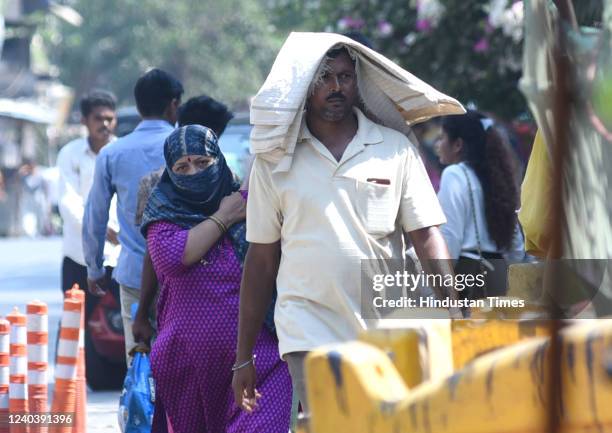 People walk in a market during a hot summer day at Vile Parle, on April 30, 2022 in Mumbai, India.