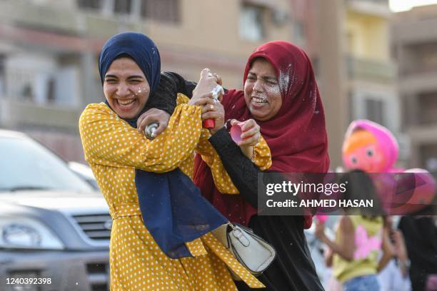 Egyptian Muslim women spray foam on each other after prayers on the first day of Eid al-Fitr, which marks the end of the holy fasting month of...