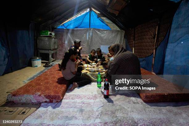 Palestinian family eats breakfast on the last day of the holy month of Ramadan inside a temporary tent in Khan Yunis in the southern Gaza Strip.