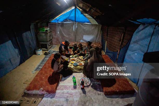 Palestinian family eats breakfast on the last day of the holy month of Ramadan inside a temporary tent in Khan Yunis in the southern Gaza Strip.