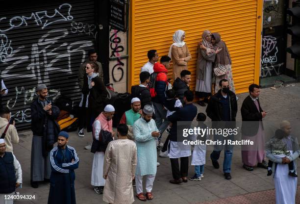 Muslim men and women gather outside the East London Mosque before morning prayers during Eid Al-Fitr celebrations on May 2, 2022 in London, England....