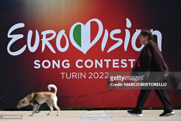 Woman walks past a banner of the Eurovision Song contest 2022 near Palalpitour, the venue of the contest, in Turin on May 2, 2022. - The contest will...