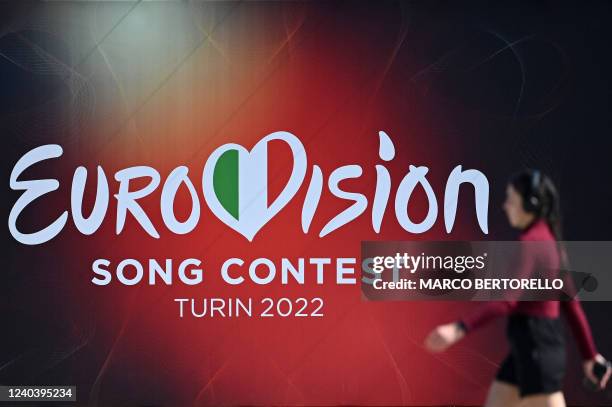 Girl walks past a banner of the Eurovision Song contest 2022 near Palalpitour, the venue of the contest, in Turin on May 2, 2022. - The contest will...