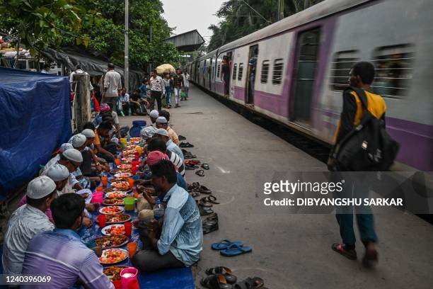 People prepare to break their Iftar fast along a railyway platform on the eve of Eid al-Fitr, which marks the end of the Muslim's holy festival of...