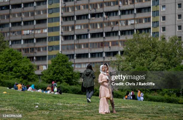Woman helps another with her head scarf during Eid Al-Fitr celebrations at Burgess Park on May 2, 2022 in London, England. Eid al-Fitr comes at the...