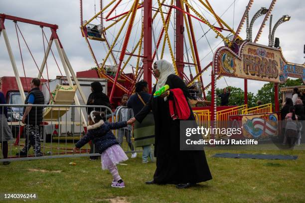 Child drags her mother towards funfair attractions during Eid Al-Fitr celebrations at Burgess Park on May 2, 2022 in London, England. Eid al-Fitr...