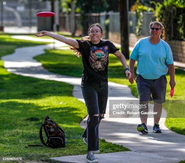 Azusa, CA, Monday, April 25, 2022 - Eric Virnala gives a pointer to his daughter, Janelle Vernal delivers her first shot as her father, Eric looks on...