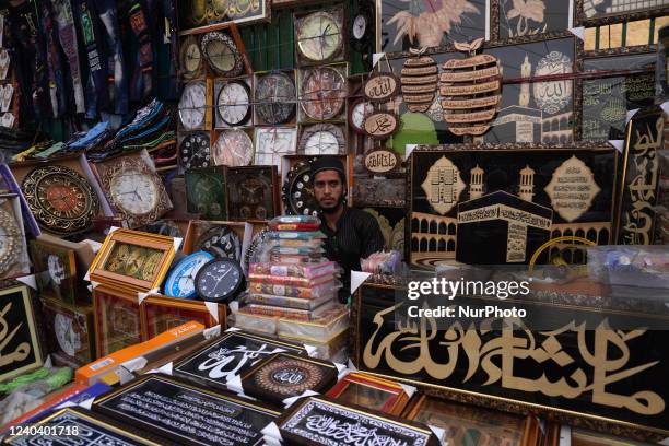 Vendor selling religious wall hangings waits for customers ahead of the Eid al-Fitr festival, which marks the end of the Muslim fasting month of...