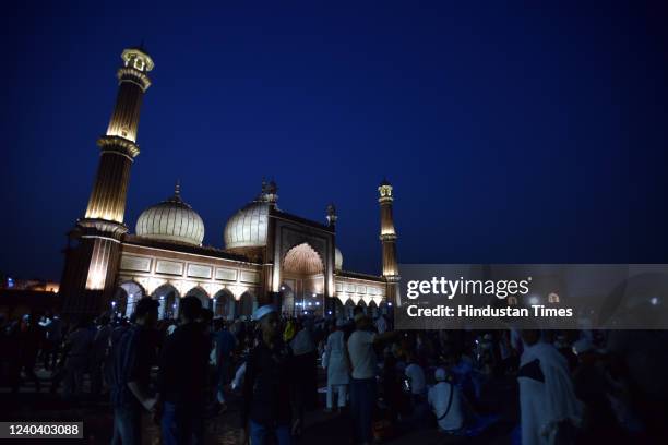 Muslim assemble for their Roza iftar in front of Illuminated Jama Masjid on the eve of Eid-ul-Fitr festival on May 2, 2022 in New Delhi, India. India...