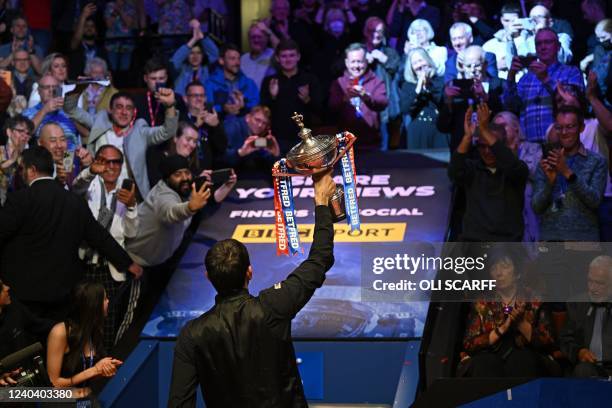 England's Ronnie O'Sullivan holds up the trophy after his victory over England's Judd Trump in the World Championship Snooker final at The Crucible...