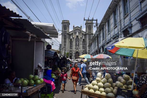 People walk through a local street market on May 2, 2022 in San Salvador, El Salvador.