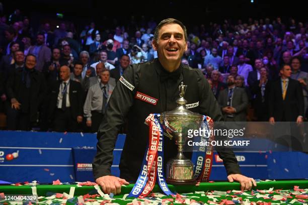 England's Ronnie O'Sullivan poses with the trophy after his victory over England's Judd Trump in the World Championship Snooker final at The Crucible...