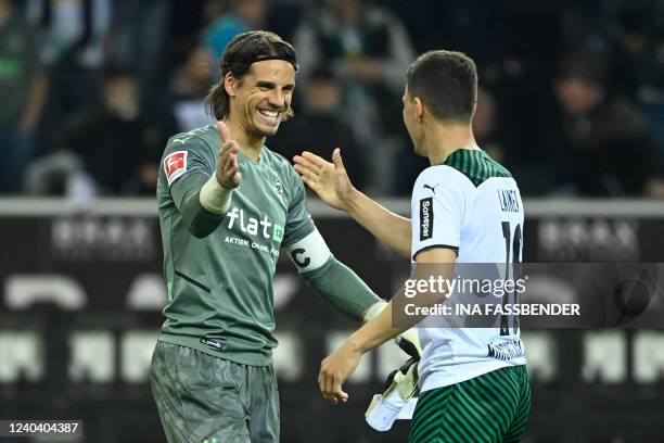 Moenchengladbach's Swiss goalkeeper Yann Sommer celebrates the team's win with Moenchengladbach's Austrian defender Stefan Lainer after the German...