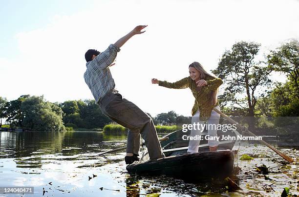 young couple enjoy playful rowing on river - gary balance foto e immagini stock