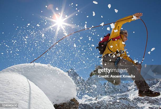 mountaineer in  mid-air jump from snowy summit - leap of faith stock pictures, royalty-free photos & images