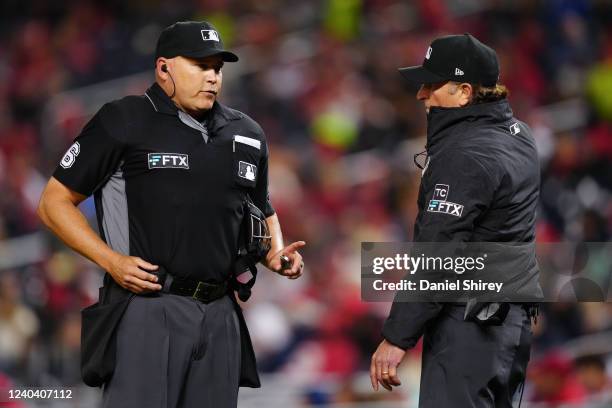 Umpire Mark Carlson and umpire Chris Guccione announce the results of a replay review to fans using the new wireless system during the game between...