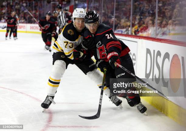 Seth Jarvis of the Carolina Hurricanes battles along the boards with Charlie McAvoy of the Boston Bruins in Game One of the First Round of the 2022...