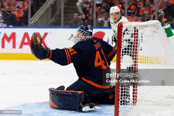 Goaltender Mike Smith of the Edmonton Oilers makes a save as Trevor Moore of the Los Angeles Kings looks on during the first period in Game One of...