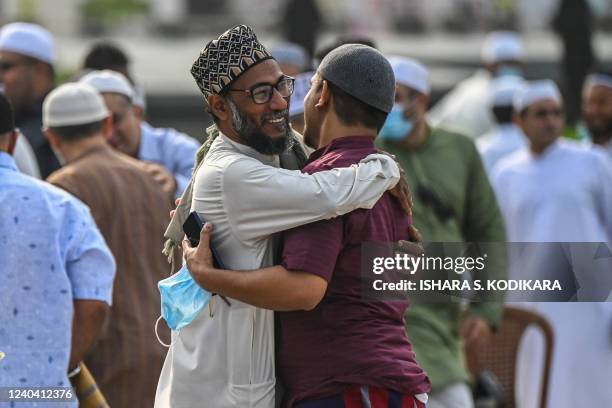 Muslim devotees greet each other after offering special morning prayers to start the Eid al-Fitr festival, which marks the end of their holy fasting...