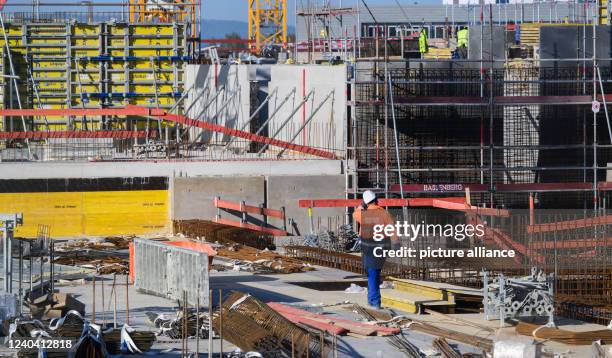 May 2022, Lower Saxony, Hanover: Construction workers stand on the building site of an apartment building in the Kronsrode development area. The...