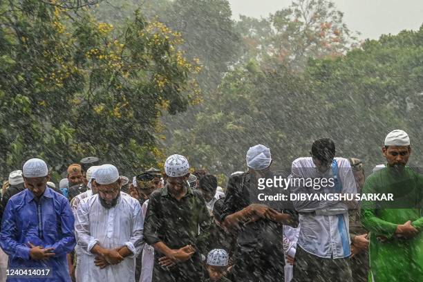Muslim devotees offer special morning prayers amid a drizzle, to start the Eid al-Fitr festival, which marks the end of their holy fasting month of...