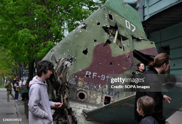 People look at the tail section of a Russian Su-25SM aircraft near the military museum in Kyiv to showcase to passersby. The attack aircraft was shot...