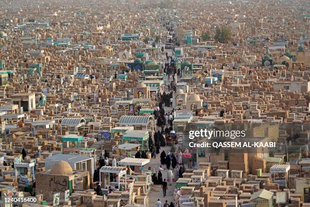 Muslims visit the graves of their relatives at the Wadi al-Salam cemetery in Iraq's holy city of Najaf during Eid al-Fitr holiday, which marks the...