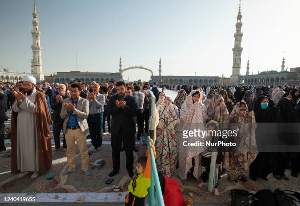 Shi'ite Muslim men and women pray at Jamkaran's holy mosque during the Eid-al-Fitr mass prayers ceremony in Qom, 145 kilometers south of Tehran, two...