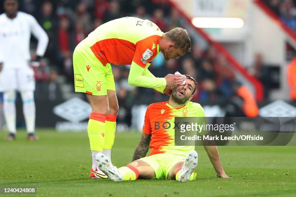 Steve Cook of Nottingham Forest is treated for a bloody head injury by teammate Joe Worrall during the Sky Bet Championship match between AFC...