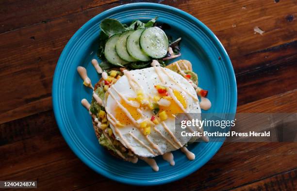 Avocado Toast, made with white bread, smashed avocado, mango salsa, spicy mayo and sunny side eggs, at Bird & Co.