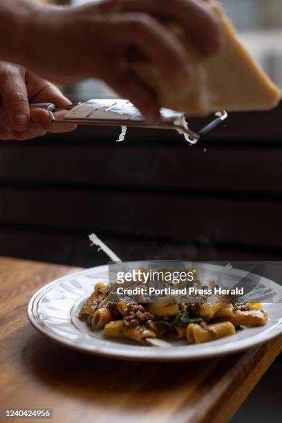 Colin Kennedy shaves parmesan cheese over the rigatoni with ragu Bolognese at Leeward on Wednesday, April 13, 2022.
