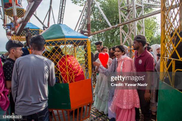 Kashmiri children along with their parents enjoy the amusement rides laid on especially for the Eid-Al-Fitr, a Muslim festival, on May 03, 2022 in...