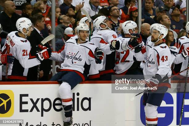 Teammates congratulate Tom Wilson of the Washington Capitals after he scored a first period goal against the Florida Panthers in Game One of the...