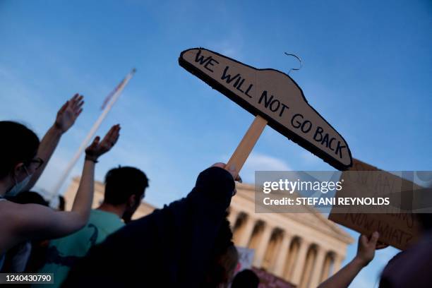 Pro-choice protester holds up a coat hanger, a symbol of the reproductive rights movement, that reads "We Will Not Go Back" outside the US Supreme...