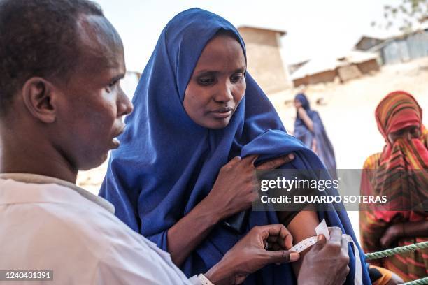 An internally displaced woman gets her arm measured during a food distribution organised by the World Food Program in the village of Adlale, near the...