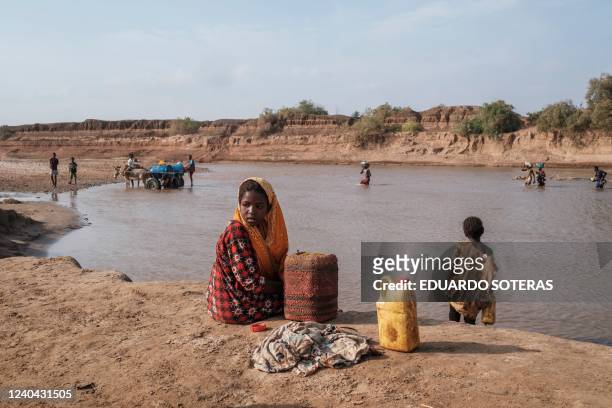 Girl looks on as she sits on the shore of the Shabelle river in the city of Gode, Ethiopia, on April 8, 2022. - The worst drought to hit the Horn of...