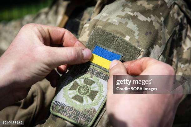 Ukrainian soldier sticks a Ukraine national flag badge to his comrade's arm during his patrol in an undisclosed location in Kharkiv oblast. As the...