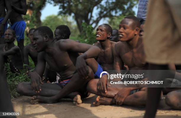 South Sudanese men look at members of their tribe, the Mundari ethnic group, wrestle in a dusty patch where the tribe brought cattle and sheep for...