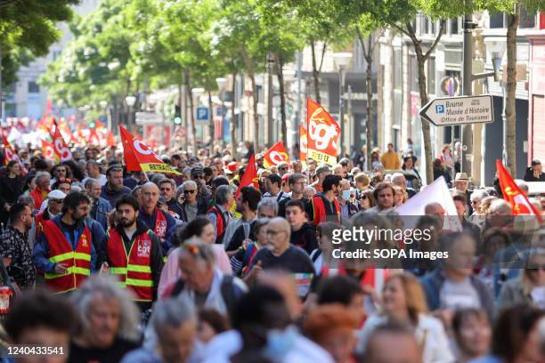Protesters march through the streets with flags and signs during the demonstration. Protesters take part in the annual May Day marking the...