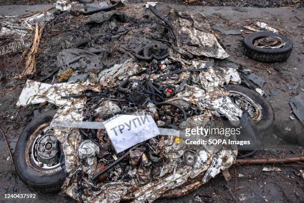 Car was destroyed by a tank. The sign says "CORPSE" to indicate dead bodies among the car ruins. Andrijvka is a village in the Bucha region in Kyiv...