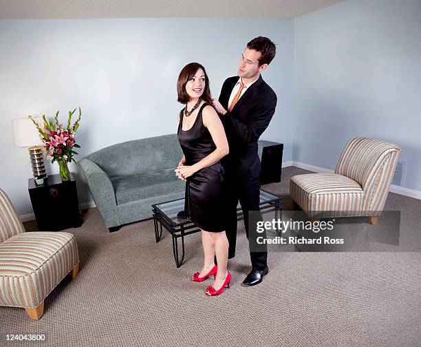 young couple in evening attire in a hotel room. - hollywood couples stock pictures, royalty-free photos & images