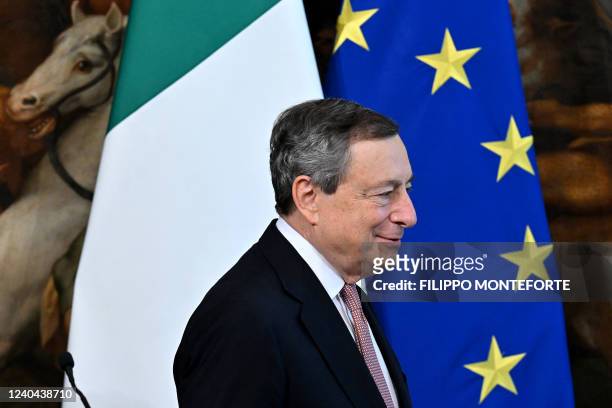 Italian Prime Minister Mario Draghi walks past the Italian and European Union flags as he arrive with the Japanese prime minister to address...