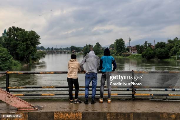 Kashmiri boys watch towards river Jhelum after rainfall in Sopore district Baramulla Jammu and Kashmir India on 04 May 2022