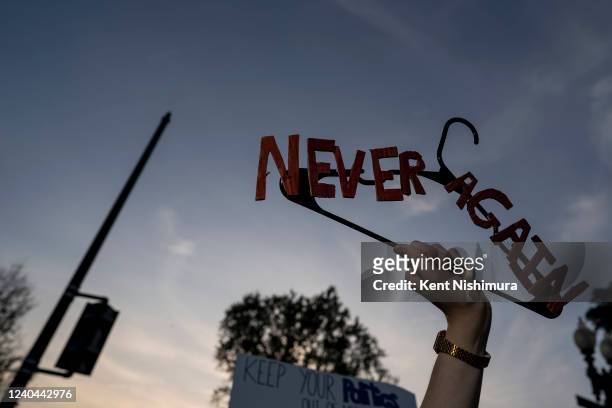 Isaac Parham holds a hanger that says Never Again as pro-choice demonstrators gather in front of the Supreme Court of the United States on Tuesday,...