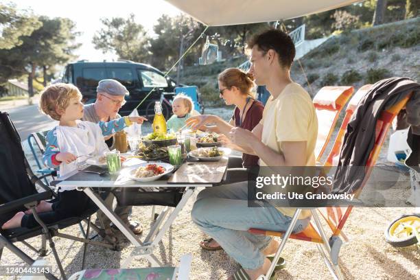 In this photo illustration a family is having a meal on a campsite.