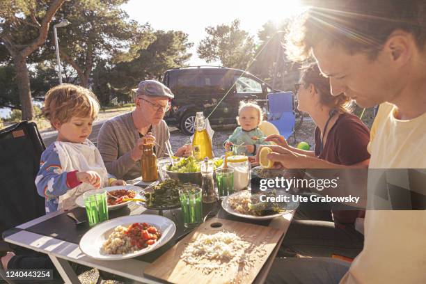 In this photo illustration a family is having a meal on a campsite.