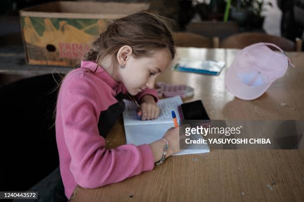 Sasha a daughter of chaplain Oleg, studies with a smartphone as she attends online schooling at the charity center managed by the pentecostal church...